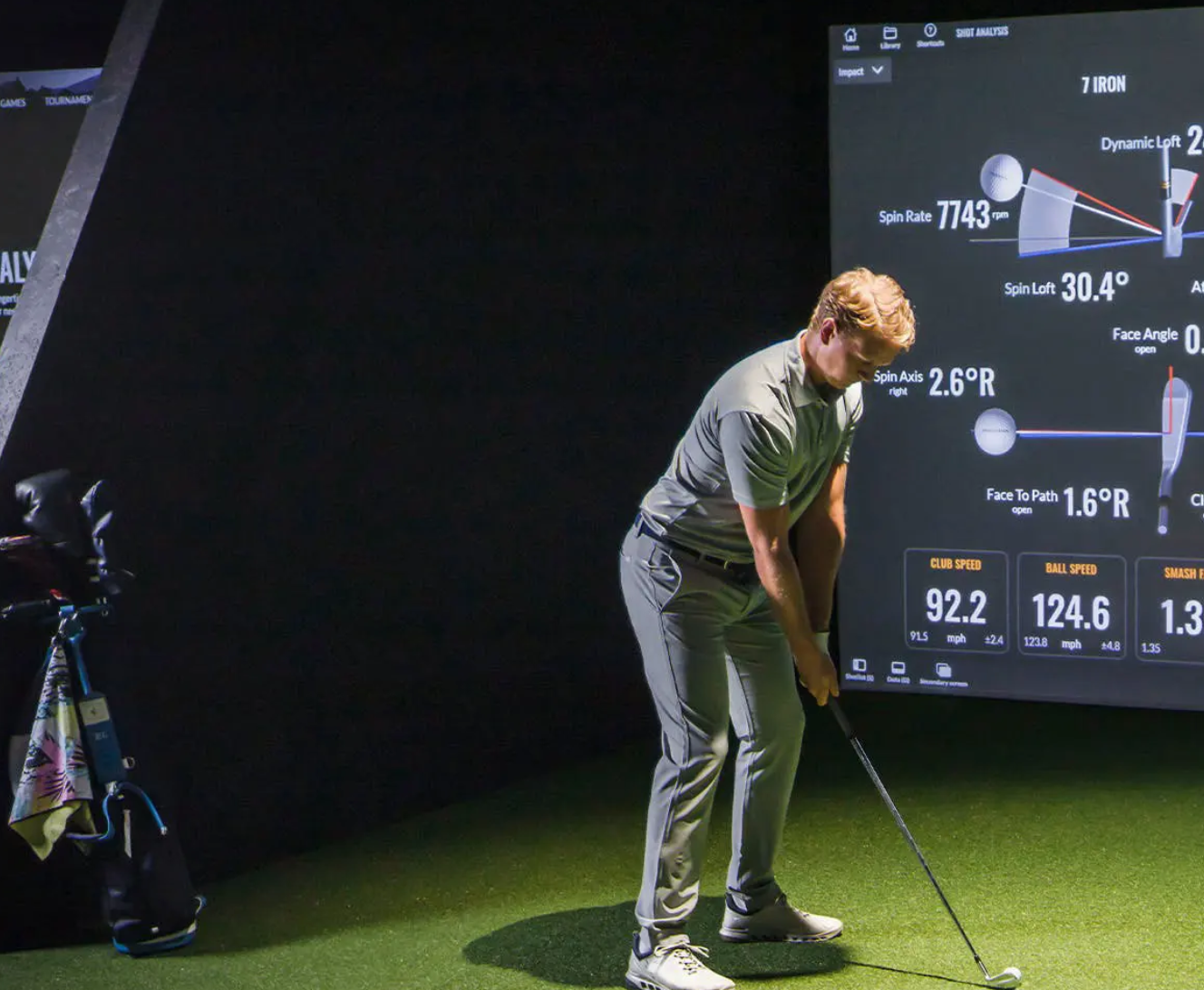Image shows a man playing golf using the Trackman gold simulator